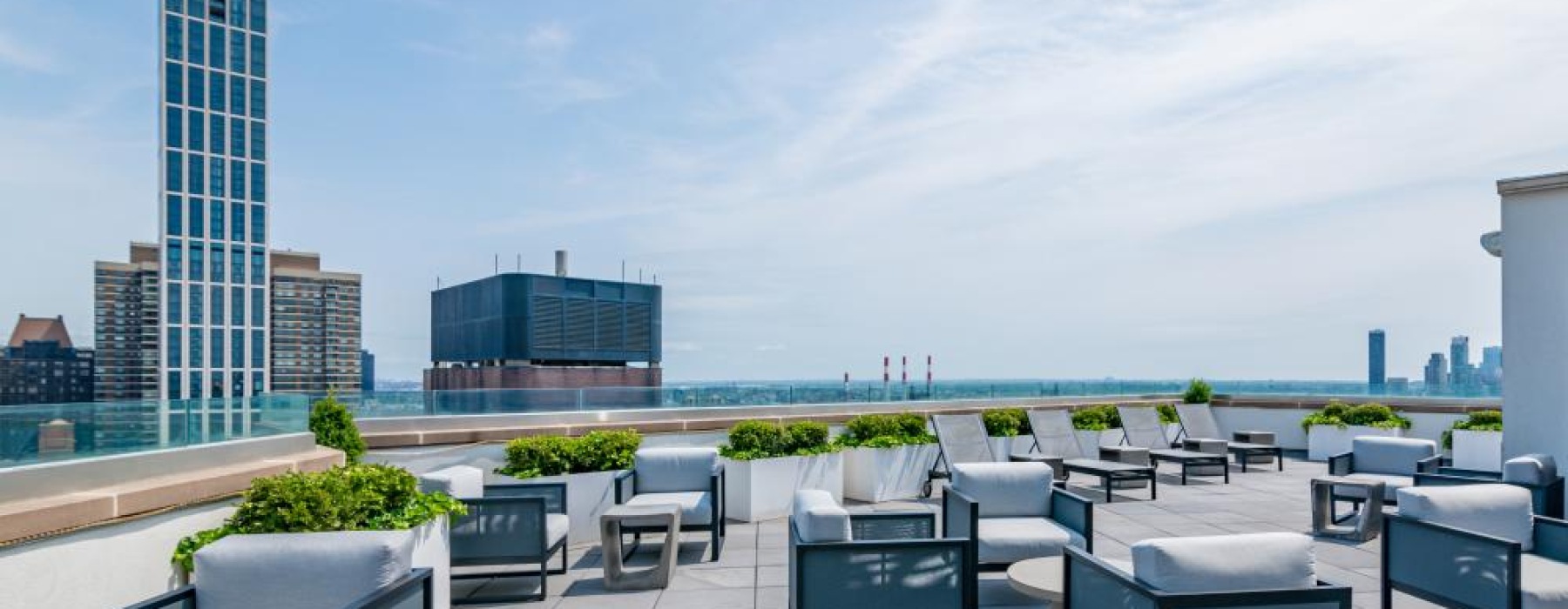 A rooftop patio with tables and chairs at Oriana apartments near Rockefeller Center in NYC.
