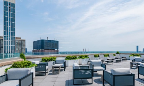 A rooftop patio with tables and chairs at Oriana apartments near Rockefeller Center in NYC.